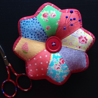 A brightly coloured patchwork pincushion