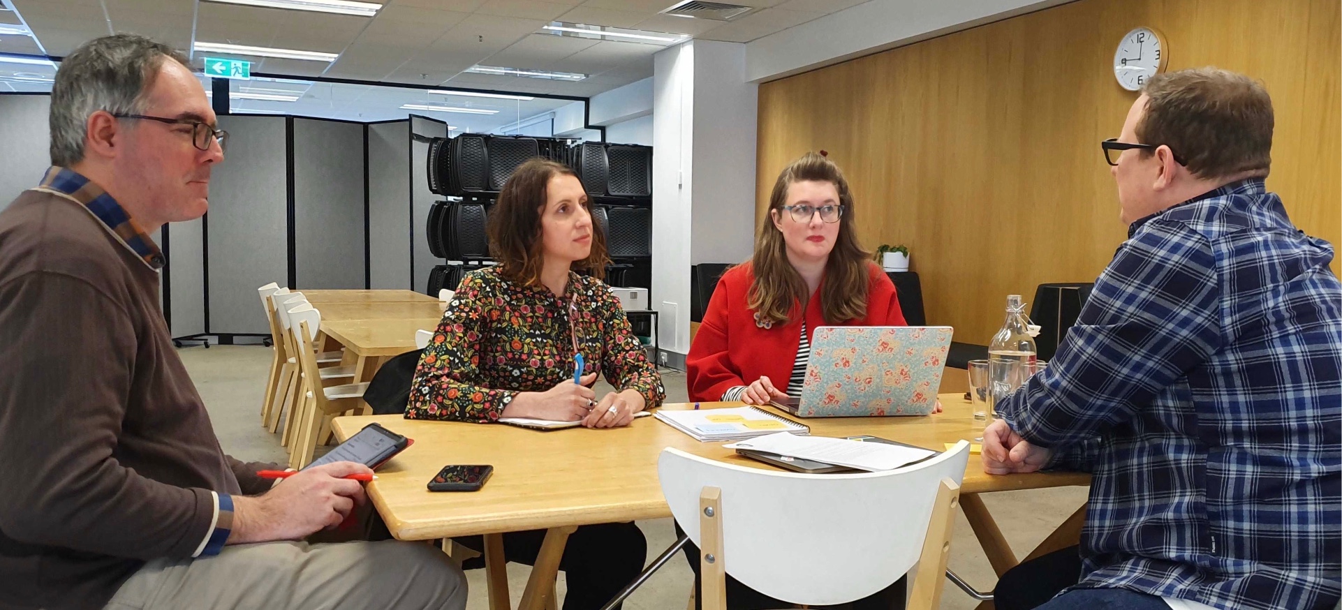 4 people sitting around a table having a meeting